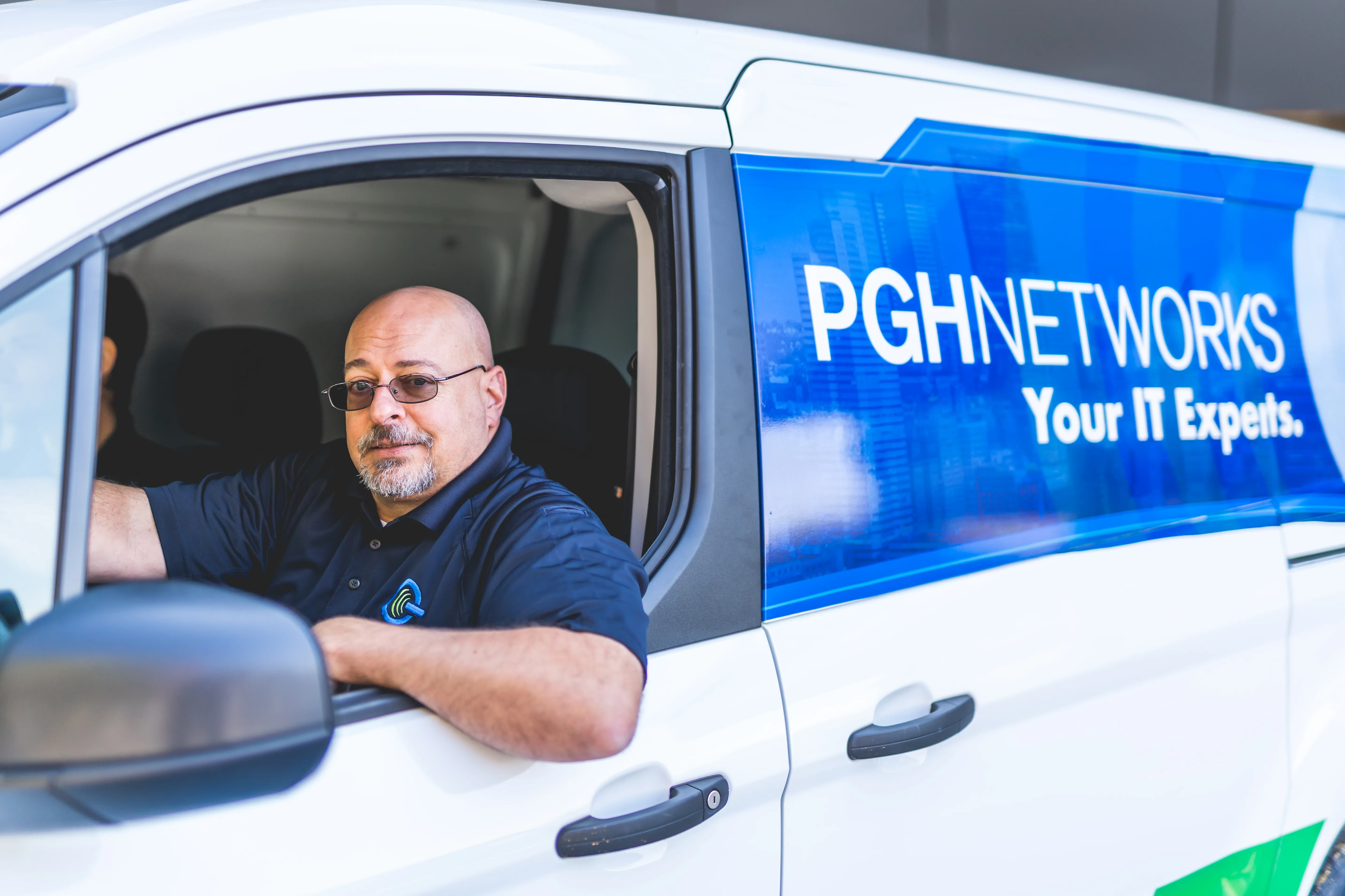 A PGH Networks technician in the company van, ready for an on-site visit.